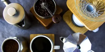 The coffee grinder, pour-over coffee, Moka pot, a cup of coffee and a milk jar for coffee brewing