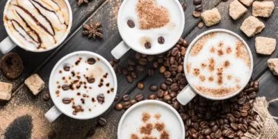 Different types of coffee in four cups nicely decorated with coffee beans